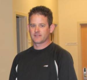 Man standing indoors, representing Sunny Carpet Cleaning, emphasizing professionalism in tile and grout cleaning services.